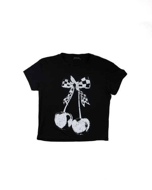 A black short-sleeve crop top t-shirt featuring a distressed white graphic of two cherries tied with a black-and-white checkered bow, shown on a plain white background.