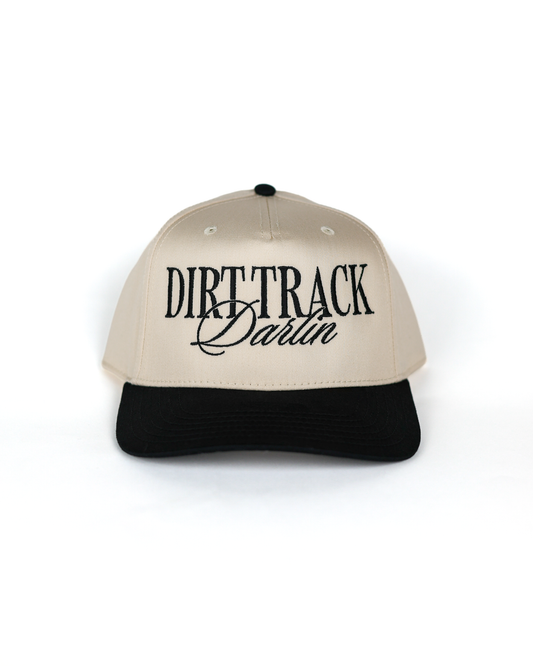 Shop the Dirt Track Darlin Hat by Race Royalty™ — a structured Otto 5-panel snapback in cream with a black brim and bold "Dirt Track Darlin" embroidery. Premium poly/cotton comfort for race day, on the go.