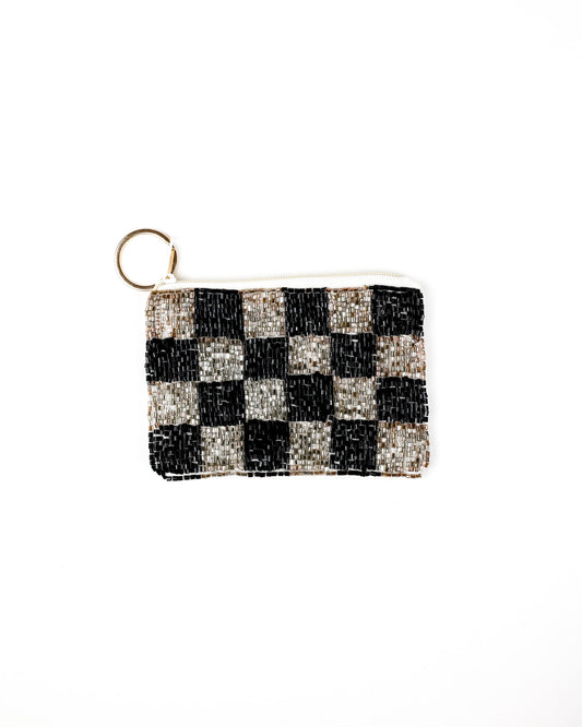A small rectangular beaded coin purse with a black and silver checkerboard pattern and a gold-tone key ring attachment, shown on a plain white background.